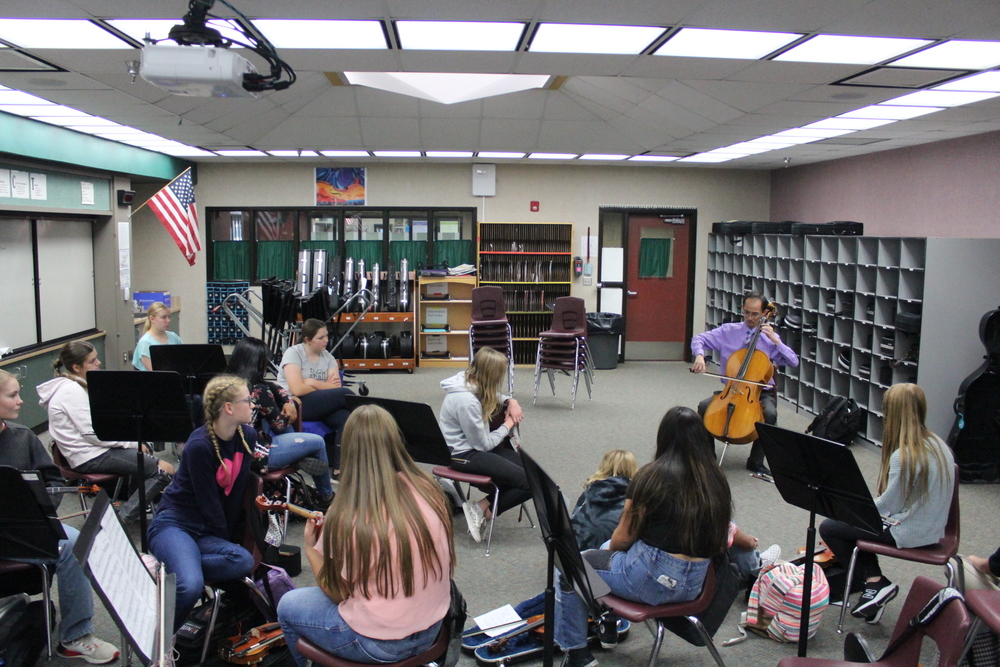 Man playing cello for students