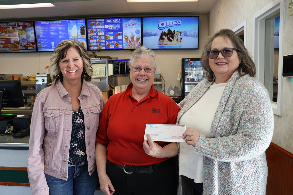 Wendy Stoker presents a check to Paula Loveland and Gina Delange, nutritions services.