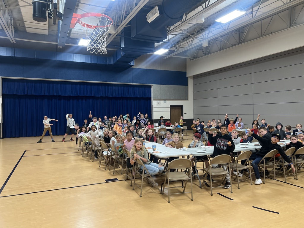 A picture of 80 students eating pizza with the principal in North elementary's gym.